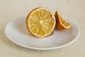 Lemon dried in the fridge. Stale citrus on a white saucer. Foods forgotten in the home refrigerator