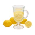 Lemon drink in a transparent glass surrounded by lemons isolated on a white background