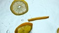 Lemon dropped transparent water closeup. Yellow vitamin fruit floating in liquid