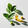 Lemon essential oil in a glass bottle with green leaves and lemon on a white background.