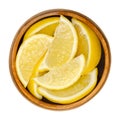 Lemon wedges, freshly cut ripe yellow citrus fruit in wooden bowl