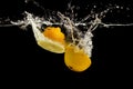 Lemon halves falling deeply under water on black background