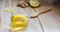 Lemon honey tea mixed with ginger in a clear glass with smoke, with a spoon and  brown sugar on a brown wood background, Healthy Royalty Free Stock Photo