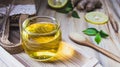 Lemon honey tea mixed with ginger in a clear glass, with a spoon and  brown sugar and hemp bag placed in a wooden tray on a brown Royalty Free Stock Photo