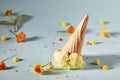 Lemon ice cream with waffle cone on blue background with yellow flowers Royalty Free Stock Photo