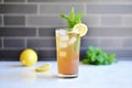 lemon iced tea in a clear cup, lemon wedge on edge, mint leaves Royalty Free Stock Photo