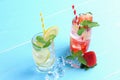 Lemon juice and strawberry juice mixing soda no alcohol in the glass garnish with mint leaves, sliced lime on blue wooden table Royalty Free Stock Photo