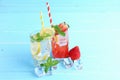 Lemon juice and strawberry juice mixing soda no alcohol in the glass garnish with mint leaves, sliced lime on blue wooden table Royalty Free Stock Photo