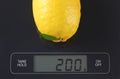 Lemon on kitchen scale Royalty Free Stock Photo