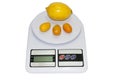 Lemon and kumquats on a kitchen digital scale Royalty Free Stock Photo