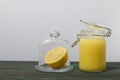 Lemon Kurd in a glass jar. Nearby is half a lemon in a container with a glass lid. Stand on brushed boards, on a white background Royalty Free Stock Photo