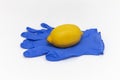 Lemon lies on a latex blue gloves on a white background Royalty Free Stock Photo