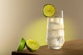 Lemon lime drink in long glass with lime fruits on the left of the shot. In the glass there is ice with light coming trough. Is Royalty Free Stock Photo