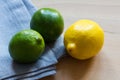 Lemon and limes with grey cloth on wooden background