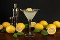 Lemon Martini cocktail, shaker and fresh fruits on wooden table Royalty Free Stock Photo