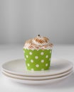 Lemon meringue cupcakes in a green cupcake case on a white plate