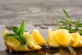 Lemon and mint leaves served on wooden kitchen board on concrete table, ingredient for summer cocktails and lemonade Royalty Free Stock Photo