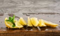 Lemon and mint leaves served on wooden kitchen board on concrete table, ingredient for summer cocktails and lemonade Royalty Free Stock Photo