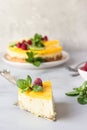 Lemon mousse vanilla cheesecake with lemon curd decorated by lemon and lime slices, frozen raspberry and mint. Royalty Free Stock Photo