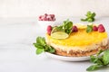 Lemon mousse vanilla cheesecake with lemon curd decorated by lemon and lime slices, frozen raspberry and mint. Royalty Free Stock Photo