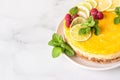 Lemon mousse vanilla cheesecake with lemon curd decorated by lemon and lime slices, frozen raspberry and mint. Royalty Free Stock Photo