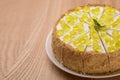 Lemon multi layered cake decorated with citron jelly and mint served on white plate on wooden background. Royalty Free Stock Photo