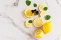 Lemon oil in a bottle with a ppetka with green melisa leaves and lemon slices on a white marble background. top view. moisturizing Royalty Free Stock Photo
