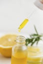 Lemon oil dropping in the bottle, aromatherapy spa essential oil dropper and bottle, closeup