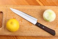Lemon, onion and kitchen knife on a wooden board Royalty Free Stock Photo