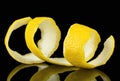 Lemon peel or lemon twist on black background. Lemon slice as cocktail ingredient