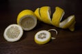 Lemon peel or lemon twist on a dark brown wooden background. Lemon slices are cut across. Close up. Royalty Free Stock Photo