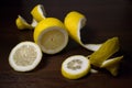 Lemon peel or lemon twist on a dark brown wooden background. Lemon slices are cut across. Close up. Royalty Free Stock Photo