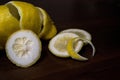 Lemon peel or lemon twist on a dark brown wooden background. Lemon slices are cut across. Close up. Royalty Free Stock Photo