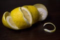 Lemon peel or lemon twist on a dark brown wooden background. Lemon slices are cut across. Close up. Citrus limon Royalty Free Stock Photo