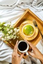 Lemon Pistachio Donut with cup of coffee, fork and flowers served in plate Isolated on wooden tray top view of baked breakfast