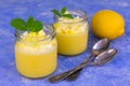 Lemon pudding or Kurd decorated with mint on a light blue background. Copy space.