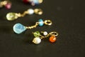 Lemon quartz, ruby, pearl,labradorite,apatite, green chalcedony, blue topaz necklace charm isolated on black background.