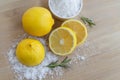 Lemon and sea salt - Beauty treatment with organic cosmetics with lemon ingredients on wood and rosemary background for body scrub Royalty Free Stock Photo