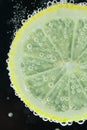 Lemon slice diving into water Royalty Free Stock Photo