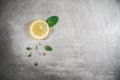 Lemon slice with mint leaves on gray table. Fresh citrous fruits piece, isolated with copyspace