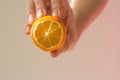 Lemon slice mock up in the hand of a young woman on a beige background with a beautiful shadow. Minimalism Royalty Free Stock Photo