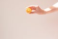 Lemon slice mock up in the hand of a young woman on a beige background with a beautiful shadow. Minimalism Royalty Free Stock Photo