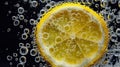 Lemon slice submerged in carbonated water with bubbles Royalty Free Stock Photo