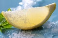 Lemon slice in sugar with mint and ice on blue background Royalty Free Stock Photo