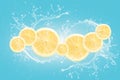 Lemon slices with water splash isolated on blue blackground