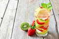 Lemon, strawberry, kiwi detox water against rustic wood Royalty Free Stock Photo