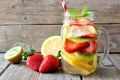 Lemon, strawberry, kiwi detox water in mason jar against wood