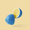 Lemon sureal playful with a blue skin cut into two parts levitation above the background.