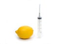 Lemon and syringe on a white background close-up, genetically modified organism. GMO. Vitamins.