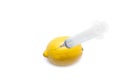 Lemon and syringe on a white background close-up, genetically modified organism. GMO. Vitamins.